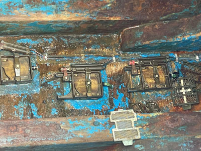 写真2　船底に配置された空気圧駆動式開閉弁<br>下マツラに置かれている網戸(目止)
