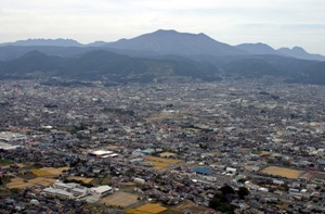 長野市南東からの空撮写真です。中央には長野市街地、奥には飯縄山が写っています。