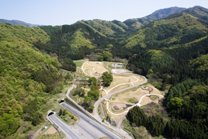 史跡大室古墳群の空撮写真です。手前に上信越自動車道、中央にエントランスゾーンの古墳群が写っていて、上部には大室古墳館が見えます。