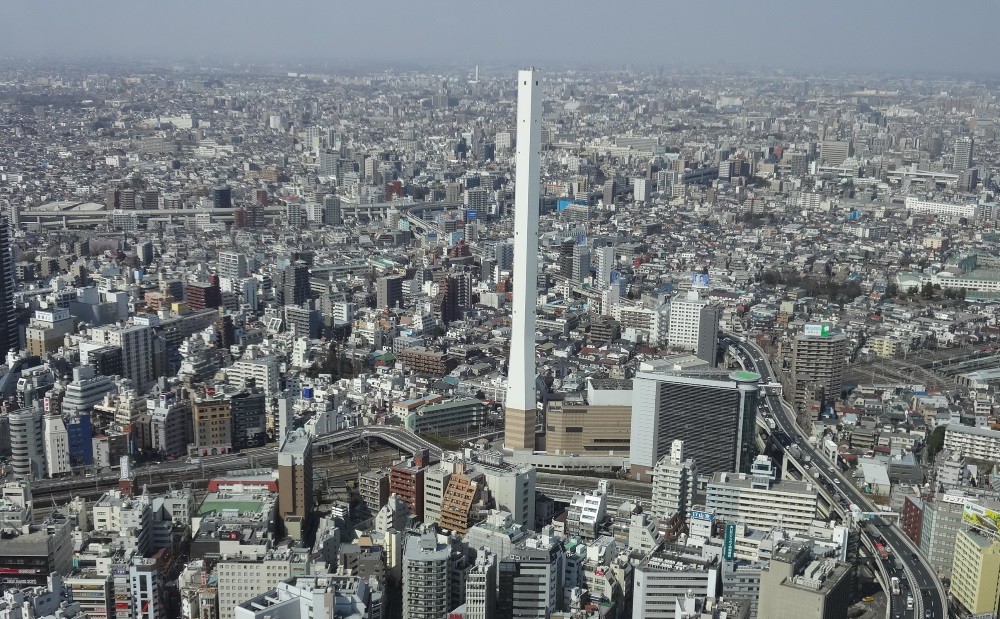 副都心池袋の街中にそびえ立つ豊島清掃工場の白い煙突（高さ210メートル）